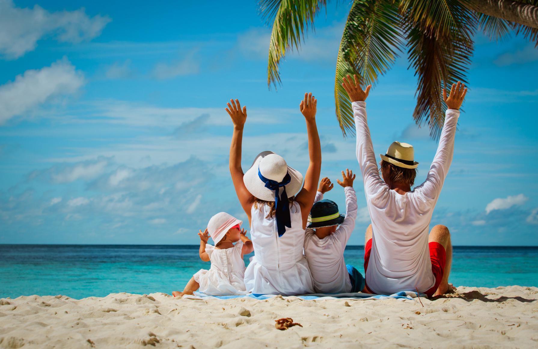 happy-family-with-two-kids-hands-up-on-beach-picture-id677652068_0