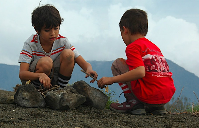 Young campers making campfire