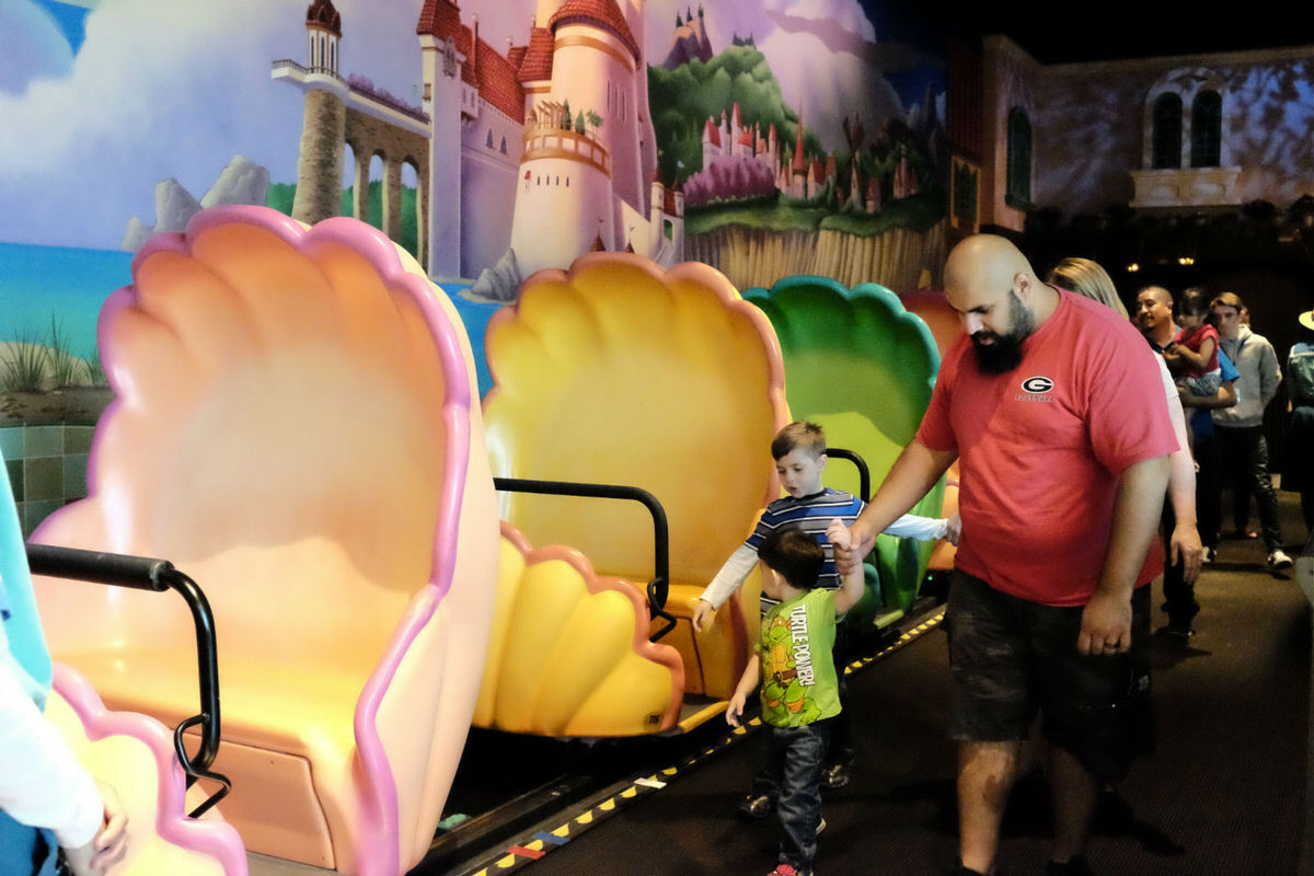 Family getting on the Little Mermaid Ride.